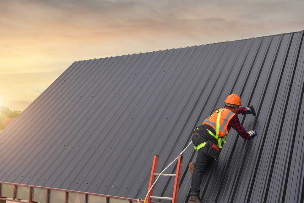 A house roof showing visible wear on sun-exposed asphalt shingles under a clear afternoon sky.