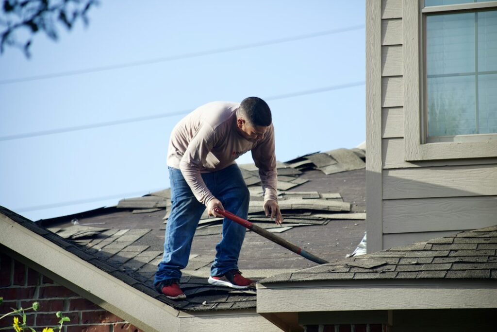 Homeowner reviews a detailed roofing proposal with a contractor beside a residential roof.